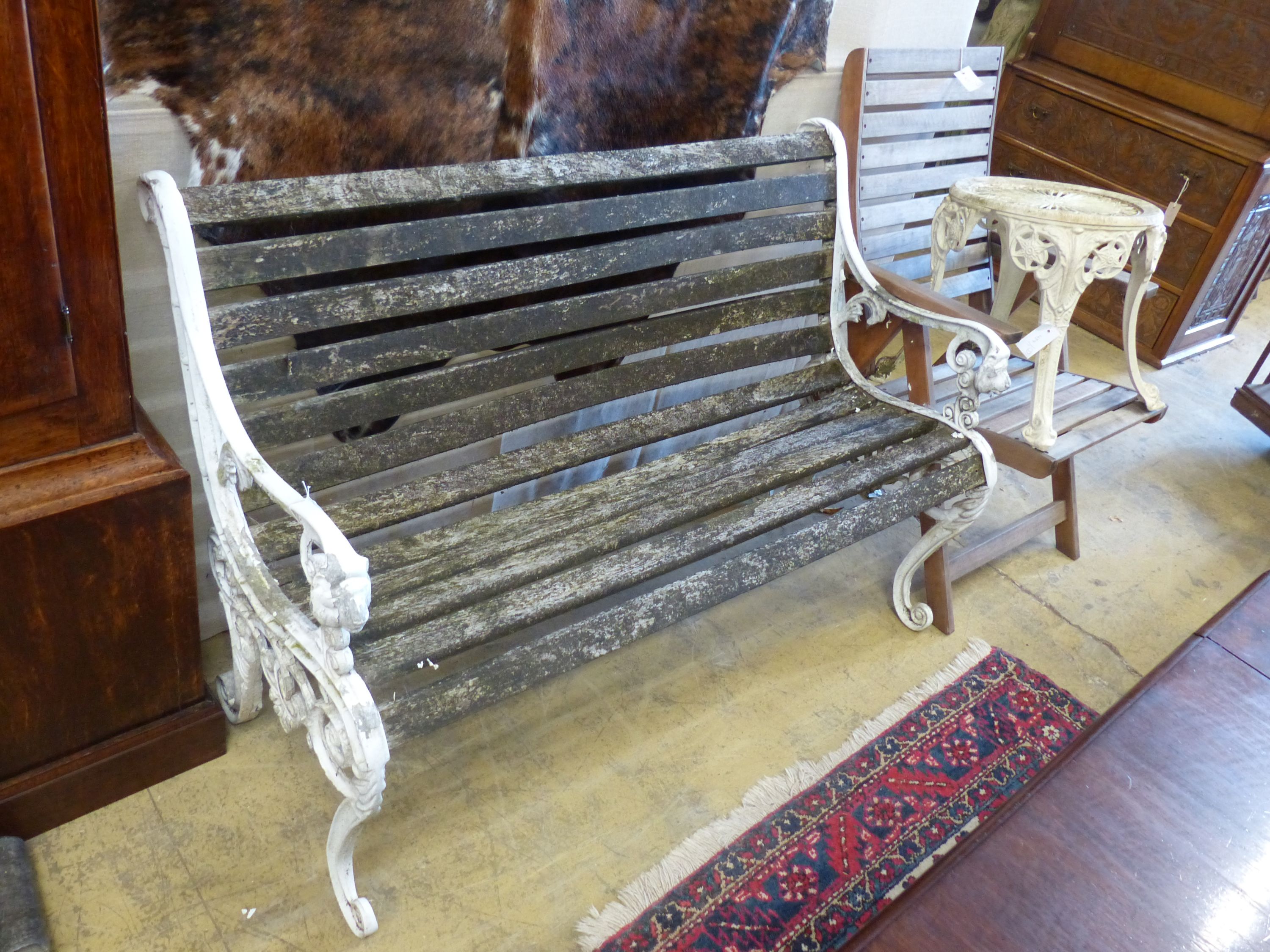 A cast metal slatted garden bench, length 125cm, together with a circualr table and a teak folding garden chair